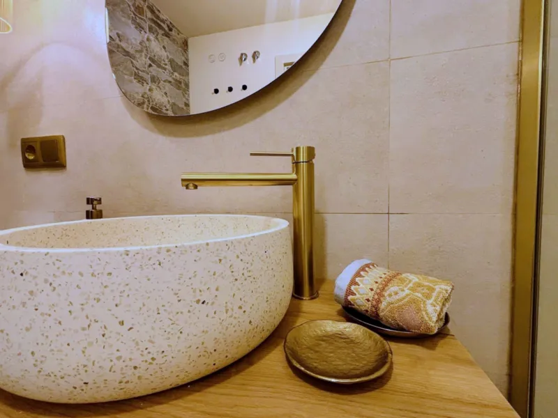 Terrazzo basin with a brass tap