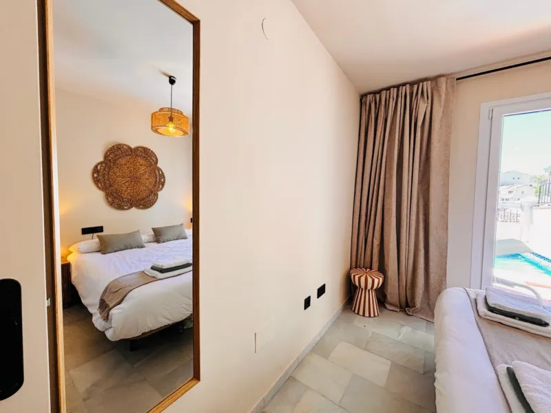 Bedroom 1 with a mirror and the terrace doors
