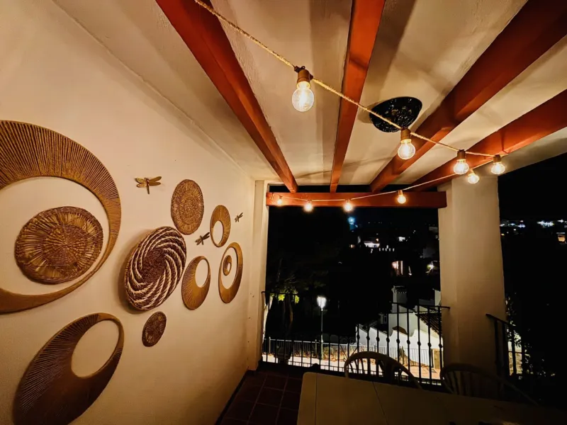 Covered terrace with string lights at night