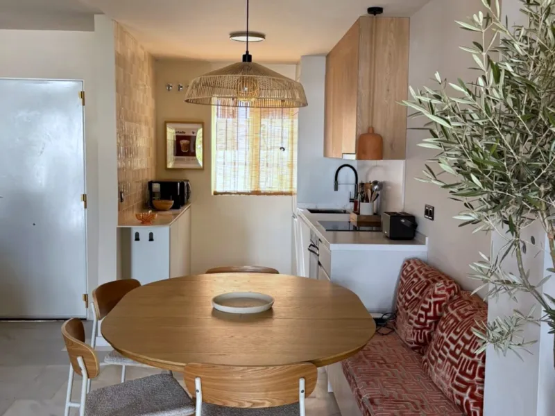 Dining corner with an olive tree and patterned cushions