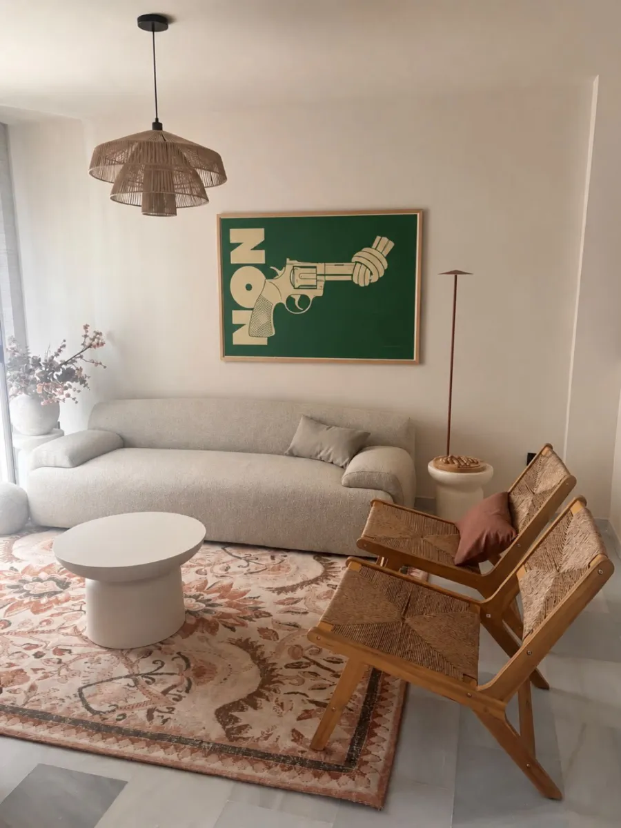 Living room with the green Non-Violence poster above the sofa