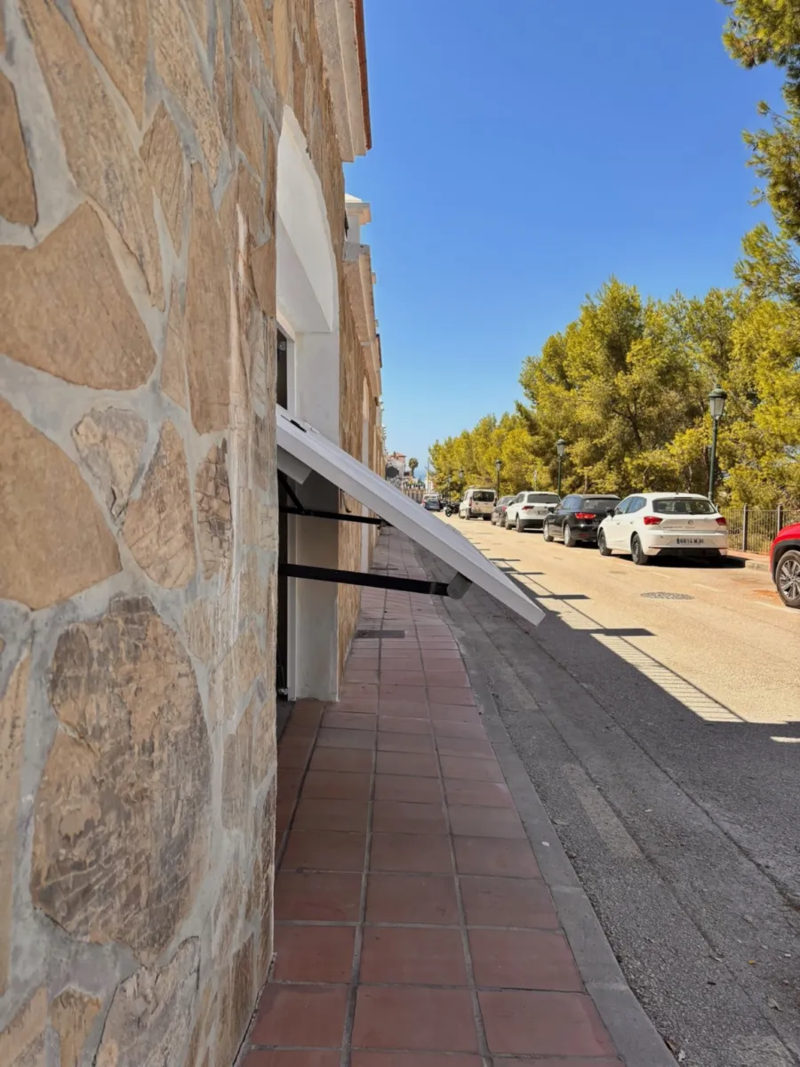 Street along the stone wall and the garage