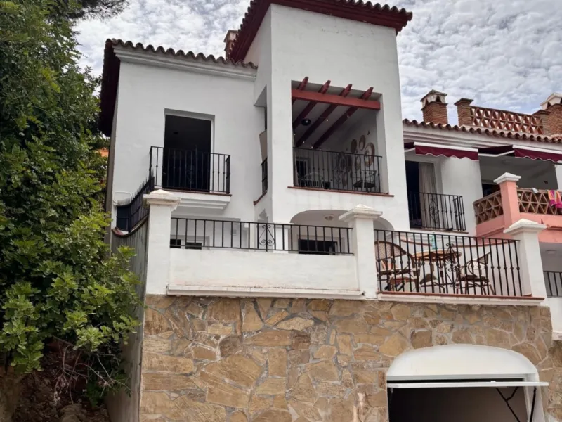 The house above its stone garage wall
