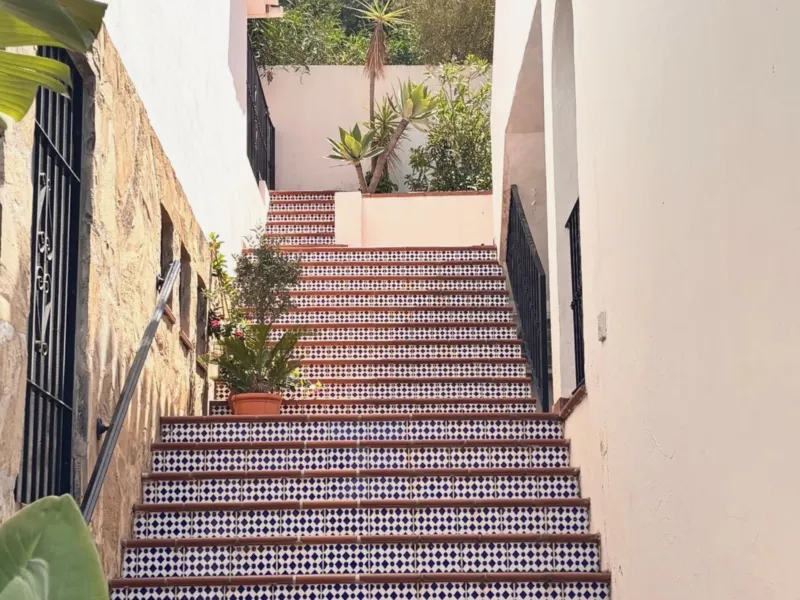 Tiled stairs between whitewashed walls